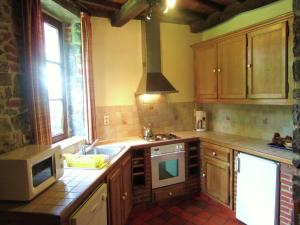a kitchen with a sink and a stove at Riverside Retreat Viroinval in Treignes