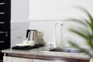 a kitchen counter with a sink and a coffee maker at Budget Hotel Rooms In Yerevan in Yerevan