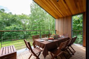 a dining room with a table and chairs on a deck at Shion - 森音 in Kutchan