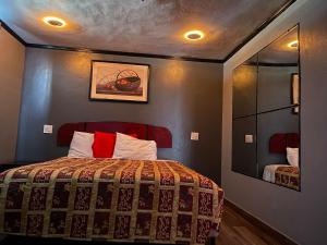 a bedroom with a bed and a mirror in it at Broadway Inn Motel in Los Angeles