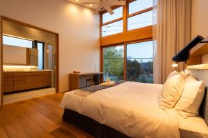 a bedroom with a large bed and a large window at Ro-An 炉庵 in Kutchan