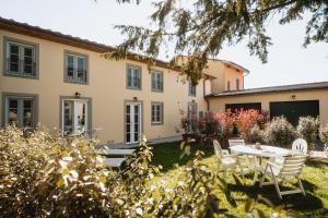 an exterior view of a house with a table and chairs at L'oasi di Renata in Lammari