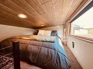 a bed in a small room with a large window at Tiny House Farm Stay Pets Welcome in Battle Ground
