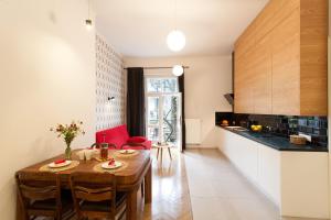 cocina y comedor con mesa y sillas en Honey Time Apartment, en Cracovia