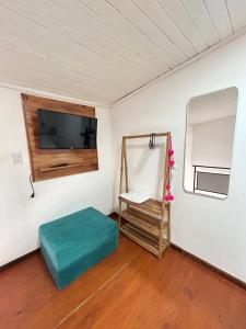 a room with a television and a green ottoman at Loft Costanera in Posadas