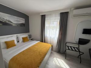 a bedroom with a bed and a chair and a window at Olive Depadance in Mostar