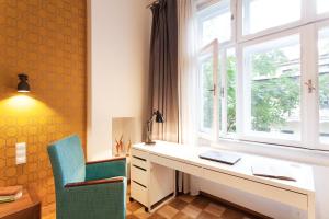 escritorio y silla en una habitación con ventana en Honey Time Apartment, en Cracovia