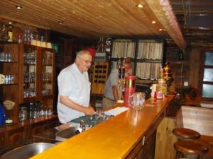 a man standing at a counter in a bar at Chalet Glamping in Myza Igaste