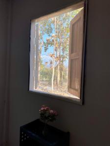 a window with a vase of flowers on a table at Teak Soul Home in Ban Na Toeng Nai