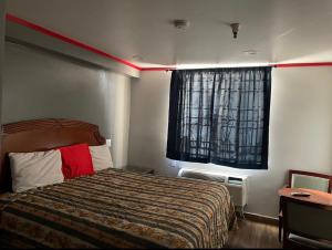 a hotel room with a bed and a window at Broadway Inn Motel in Los Angeles +15 photos