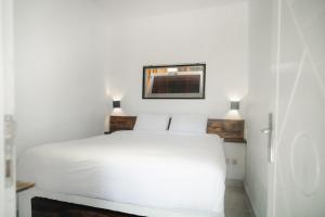 a bedroom with a white bed and two lamps at Comuna Tigabelas in Gisi