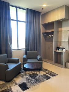 a living room with two couches and a coffee table at The Quadrant Hotel Ocarina Batam in Batam Center