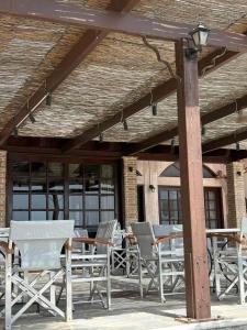 a group of tables and chairs on a patio at Zakros Beach hotel in Tolo