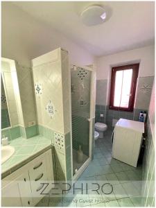 a bathroom with a shower and a sink and a toilet at Zephiro Guest House in La Maddalena