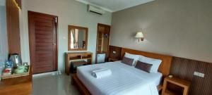 a bedroom with a large white bed in a room at Umayuri Inn in Ubud