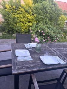 a wooden table with a vase of flowers on it at Hébergement proche de Atomium Expo Serres Royales in Grimbergen +5 photos