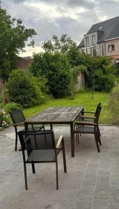 a picnic table and two chairs on a patio at Hébergement proche de Atomium Expo Serres Royales in Grimbergen