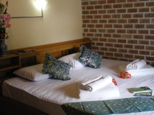 uma cama num quarto com uma parede de tijolos em Sukorn Andaman Beach Resort em Ko Sukon