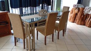 a dining room with a glass table and chairs at Leisure Seaview House in Port Edward