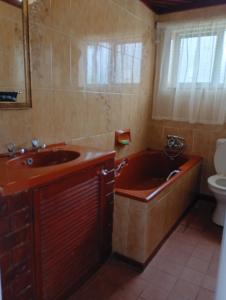 a bathroom with a tub and a sink and a toilet at Leisure Seaview House in Port Edward +50 photos
