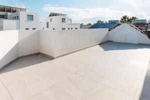 a balcony with a white wall and a tile floor at Modern Studio Loft in Central Larnaca with WiFi in Larnaca