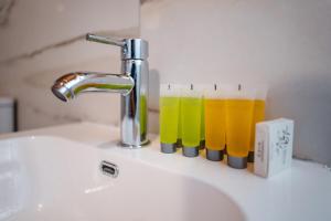 a sink with a faucet and three glasses of juice at Modern Studio Loft in Central Larnaca with WiFi in Larnaca +8 photos