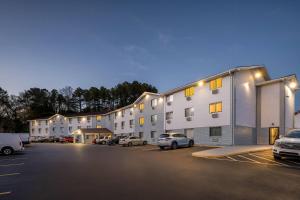 a building with cars parked in a parking lot at Super 8 by Wyndham Homewood Birmingham Area in Birmingham