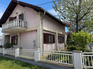 a house with a white fence in front of it at Laganini Cozy Home in Velika Mlaka