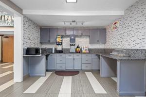 a kitchen with gray cabinets and a counter top at Super 8 by Wyndham Homewood Birmingham Area in Birmingham