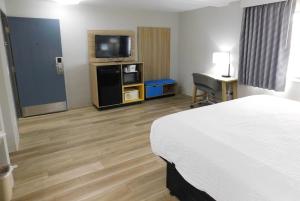 a hotel room with a bed and a flat screen tv at Days Inn by Wyndham Effingham in Effingham
