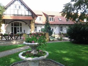 a house with a yard with a urn with flowers at Hotel Altes Badehaus in Bad Dürrenberg
