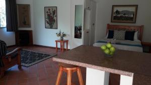 a living room with a bed and a kitchen with a table at Sanfern Downs Cottage in Haenertsburg +8 photos