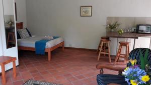 un soggiorno con un letto e un tavolo di Sanfern Downs Cottage a Haenertsburg Altre 10 foto