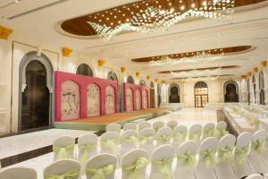a banquet hall with white chairs and a stage at Radisson Resort & Spa Sasan Gir in Junagadh +78 photos