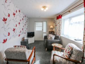a living room with a couch and a tv at Ground Floor Apartment in Porthmadog