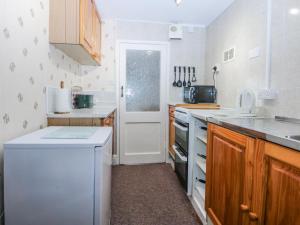 a kitchen with a white refrigerator and a dishwasher at Ground Floor Apartment in Porthmadog