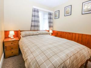 a bedroom with a large bed and a window at Ground Floor Apartment in Porthmadog