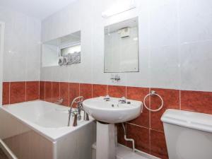 a bathroom with a sink and a tub and a toilet at Ground Floor Apartment in Porthmadog +12 photos