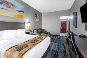 a hotel room with a large bed and a couch at La Quinta by Wyndham Tampa Central in Tampa