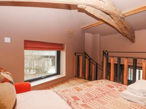 a bedroom with a bed and a window at 3 Caddaford Barns in Buckfastleigh
