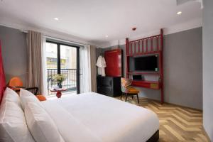 a bedroom with a large white bed and a television at Hanora Boutique Hotel in Hanoi