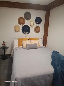 a bedroom with a large bed with hats on the wall at El Fumvial in Arnuero