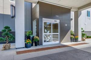 a front door of a building with potted plants at MainStay Suites Great Falls Airport in Great Falls