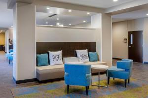 a waiting room with a couch and two blue chairs at MainStay Suites Great Falls Airport in Great Falls +49 photos
