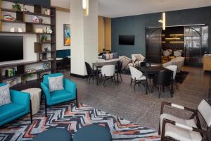 a lobby with a waiting area with chairs and tables at Tempo By Hilton Washington Dc Downtown in Washington, D.C.