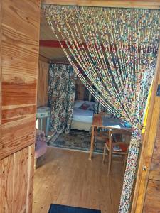 a room with a bed and a curtain at Roulotte et Cabane Par Hasard in Saint-Bressou