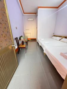 a hotel room with two beds and a table at Hotel Thúy Hằng Núi Sam Châu Đốc in áº¤p VÄ©nh ÃÃ´ng +23 photos