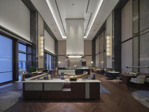 a lobby with tables and chairs in a building at Hilton Quzhou in Quzhou +87 photos