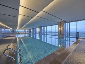 a swimming pool in a building with glass windows at Hilton Quzhou in Quzhou
