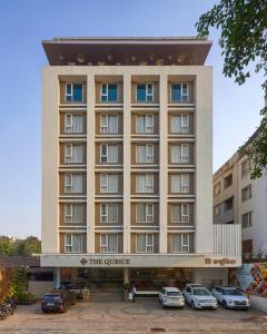 a building with cars parked in a parking lot at The Qubice Hotel, Kolhapur in Kolhapur